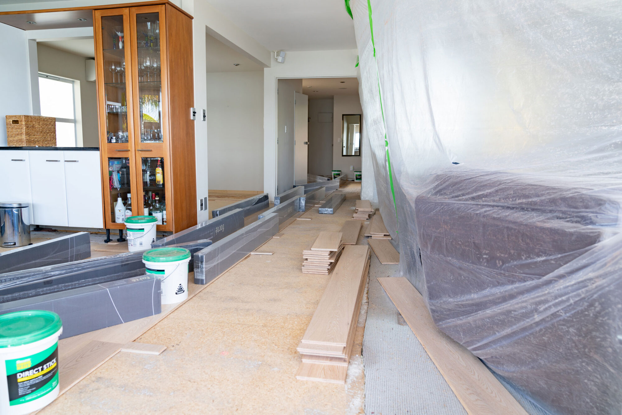 Home renovations in early stage of work. Tauranga New Zealand - November 2 2019; Home renovations underway, with room partly stripped and masked up with packages and stacks of new flooring waiting to be installed